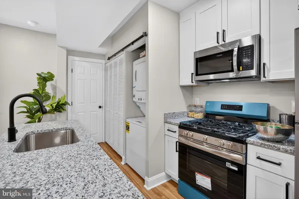 a kitchen with stainless steel appliances kitchen island a stove and a sink