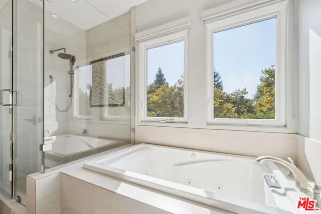 a white bath tub sitting next to a shower