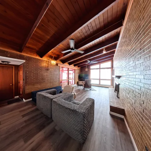 a view of a room with wooden floor and furniture