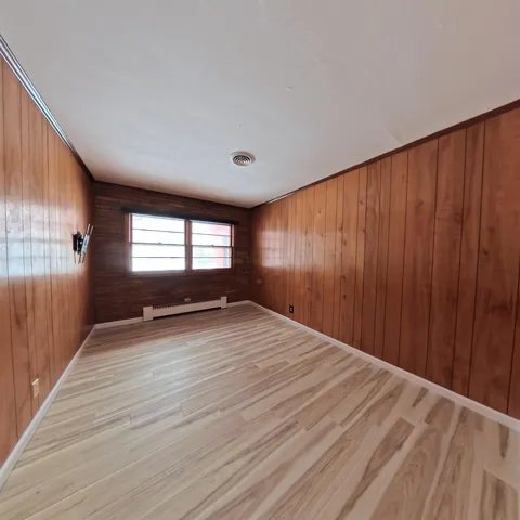 a view of a livingroom with wooden floor and a ceiling fan