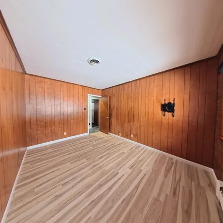 a view of a room with wooden floor and a window
