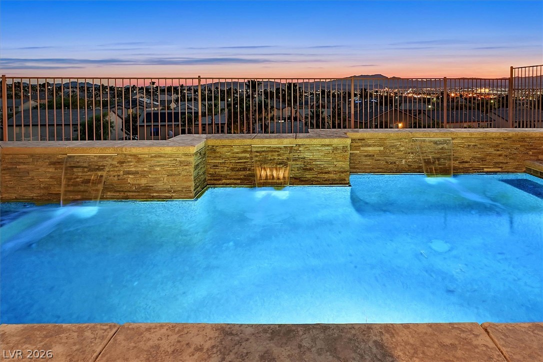 2447 Kaymin Ridge Road Henderson, NV 89052 - Photo 31 of 40 Glistening waters and cascading waterfalls create a serene outdoor oasis overlooking city lights.