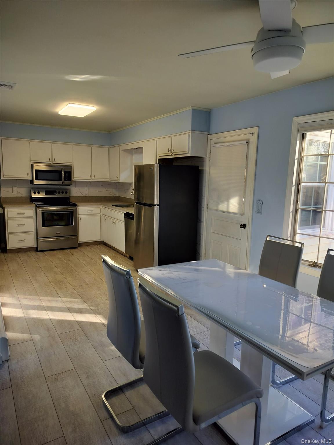 72 Martin Road Pleasant Valley, NY 12569 - Photo 4 of 5 a kitchen with stainless steel appliances a refrigerator a stove a sink a dining table and chairs