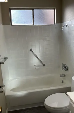 a bathroom with a toilet and a bath tub