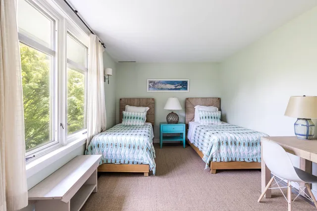 a bedroom with two beds and a large window