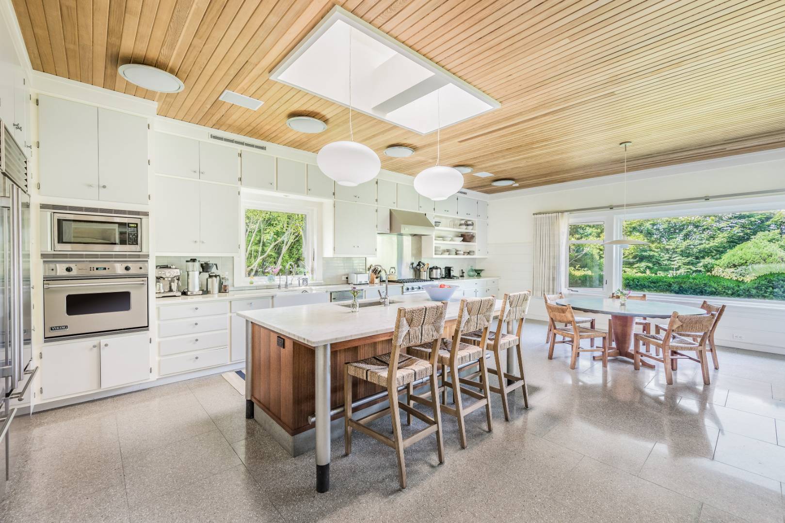 34 La Forest Lane East Hampton, NY 11937 - Photo 4 of 19 a kitchen with a table chairs and a refrigerator