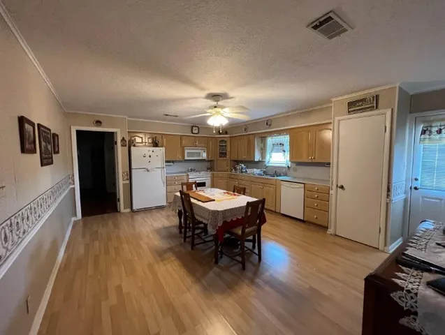 a kitchen with a dining table chairs and refrigerator