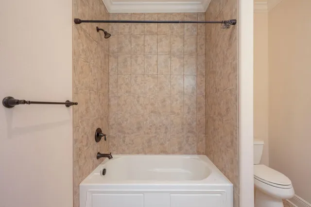 a white bath tub with a white curtain and shower curtain