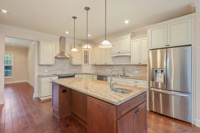 a kitchen with a refrigerator a sink and wooden floor
