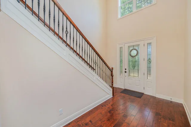 a view of staircase with wooden floor and white walls