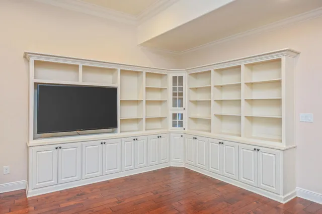 a view of an empty room with a cabinet and flat screen tv