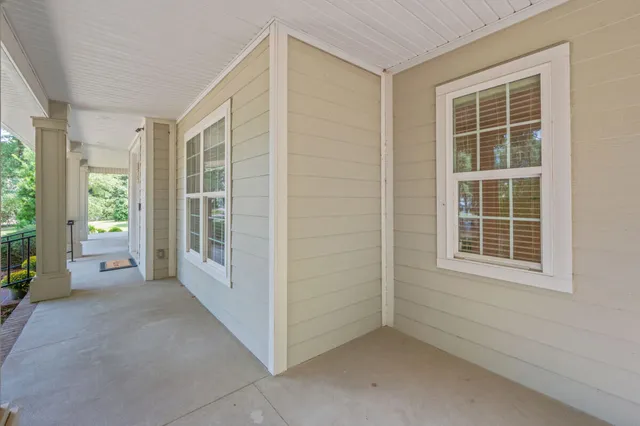 a view of a house next to a big yard and large trees