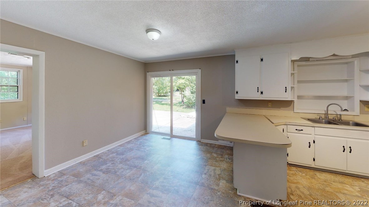7608 Decatur Drive Fayetteville, NC 28303 - Photo 12 of 36 an empty room with a sink and dishwasher with wooden floor