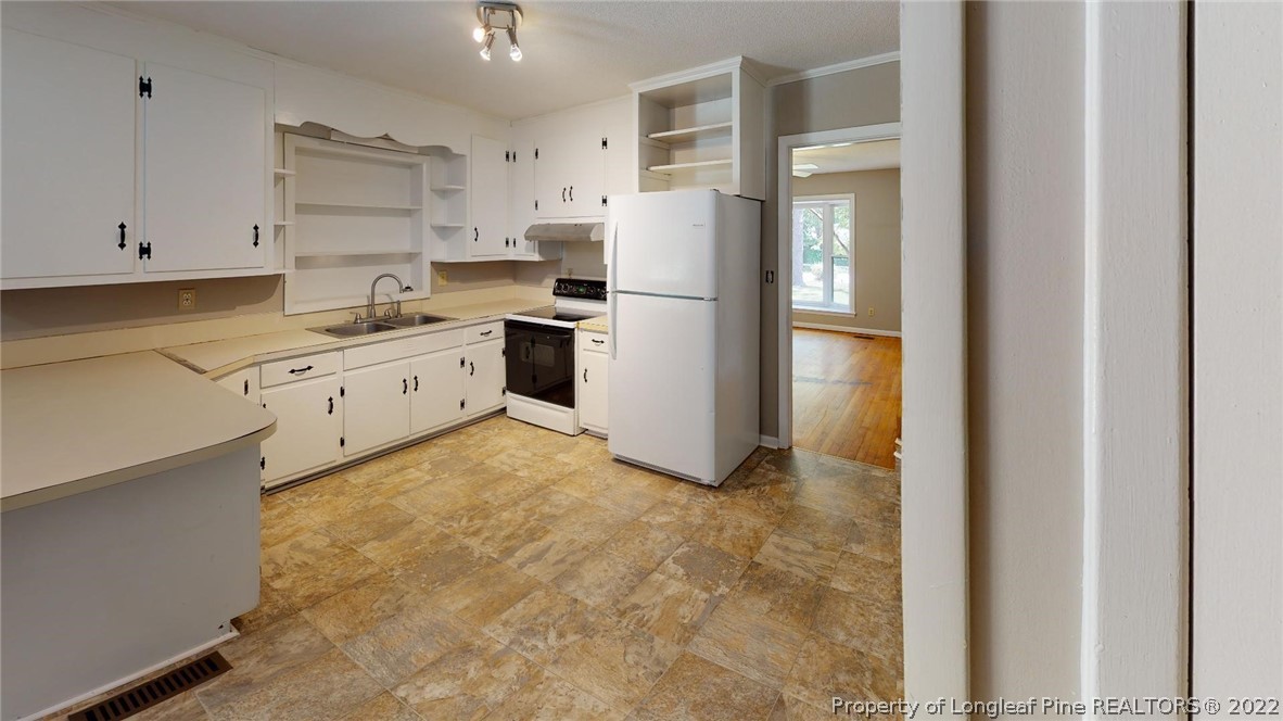 7608 Decatur Drive Fayetteville, NC 28303 - Photo 13 of 36 a kitchen with white cabinets and white appliances