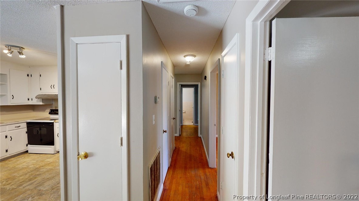 7608 Decatur Drive Fayetteville, NC 28303 - Photo 15 of 36 a view of a hallway with wooden floor and a bathroom