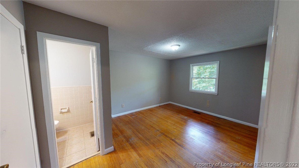 7608 Decatur Drive Fayetteville, NC 28303 - Photo 16 of 36 an empty room with wooden floor and windows