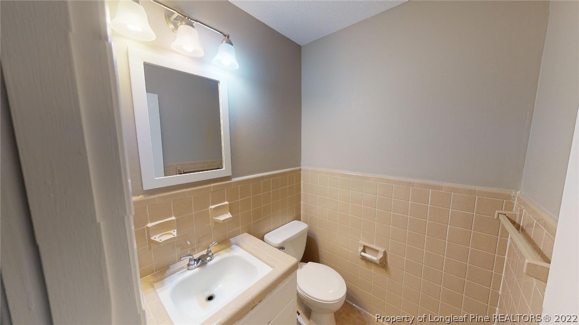 7608 Decatur Drive Fayetteville, NC 28303 - Photo 18 of 36 a bathroom with a toilet a sink and mirror