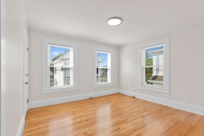 9 Foster Street, Unit 1 Gloucester, MA 01930 - Photo 5 of 13 an empty room with wooden floor and windows