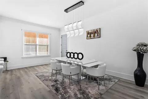 a kitchen with a sink dishwasher a dining table and chairs with wooden floor