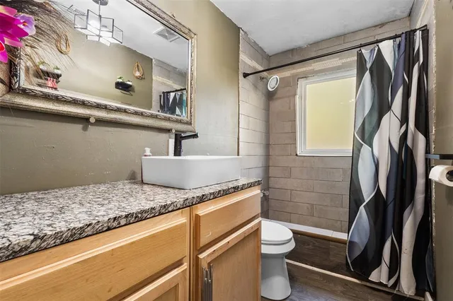 a bathroom with a granite countertop sink toilet and shower