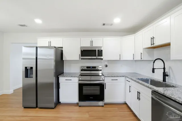 a kitchen with stainless steel appliances granite countertop a stove top oven a sink and dishwasher