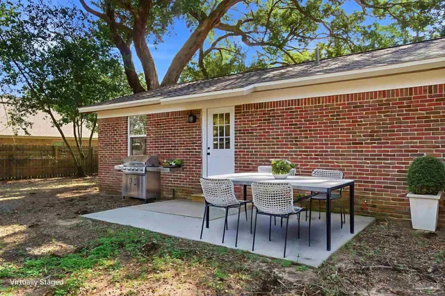 a backyard of a house with table and chairs