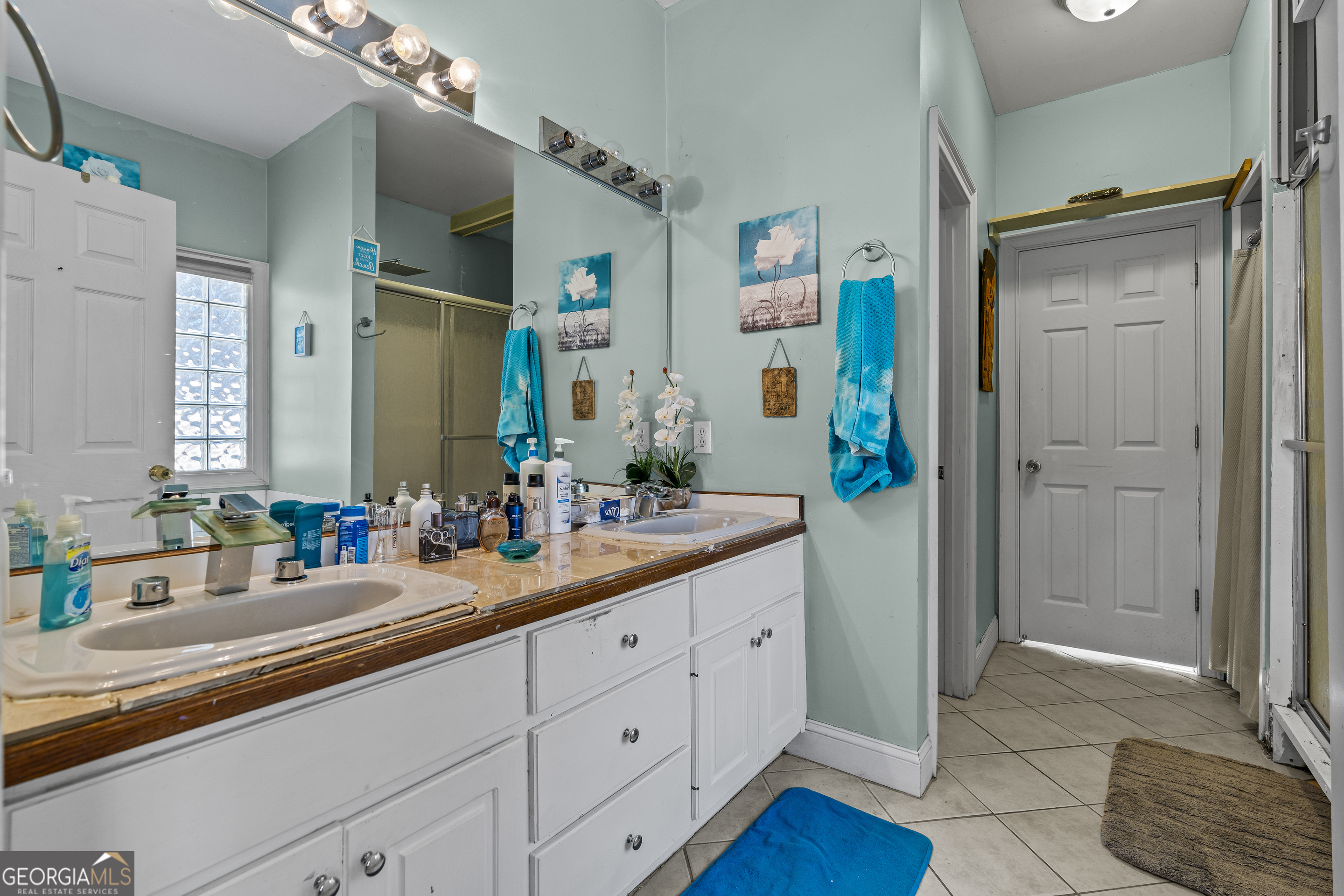 2498 Highway 212 Covington, GA 30016 - Photo 27 of 74 a bathroom with a double vanity sink a mirror and a shower
