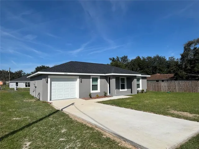 a view of a white house with a yard and fence