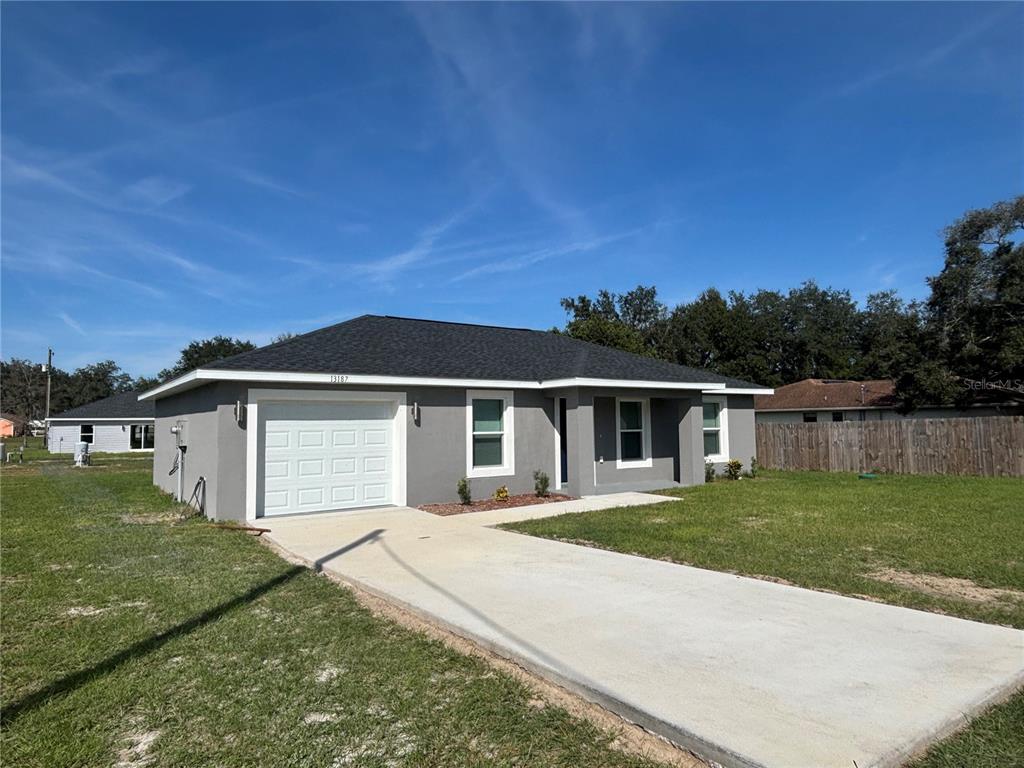 13187 Southwest 103rd Place Dunnellon, FL 34432 - Photo 2 of 24 a view of a white house with a yard and fence
