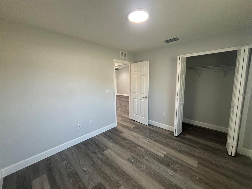 13187 Southwest 103rd Place Dunnellon, FL 34432 - Photo 9 of 24 an empty room with wooden floor and closet