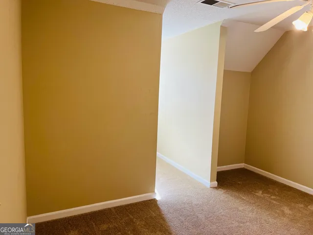 an empty room with closet and a chandelier fan