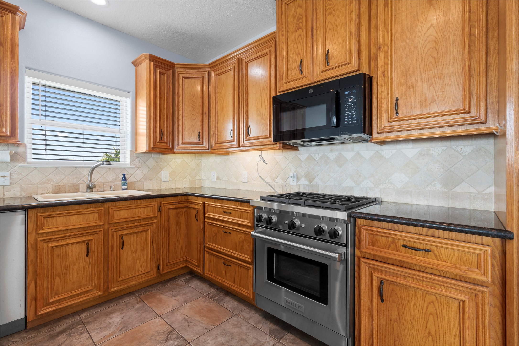 427 2nd Street San Leon, TX 77539 - Photo 17 of 30 a kitchen with granite countertop cabinets stainless steel appliances and wooden floor