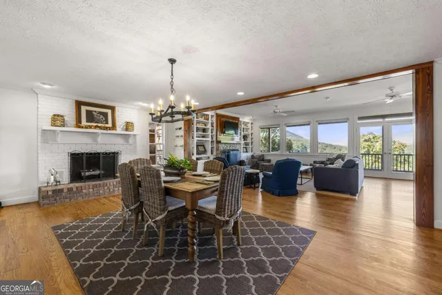 a view of a dining room with furniture a chandelier and wooden floor