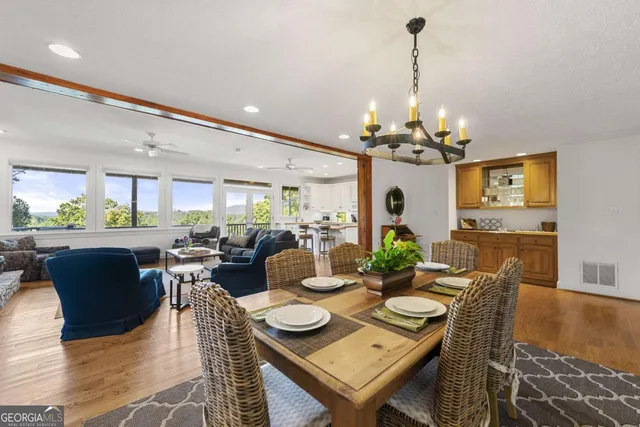 a view of a dining room with furniture a chandelier and wooden floor