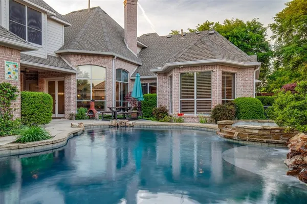 a view of house with swimming pool and outdoor seating