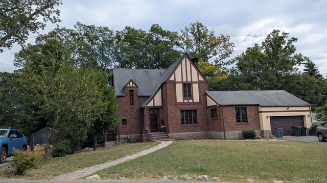 a view of a yard in front of a house with large tree