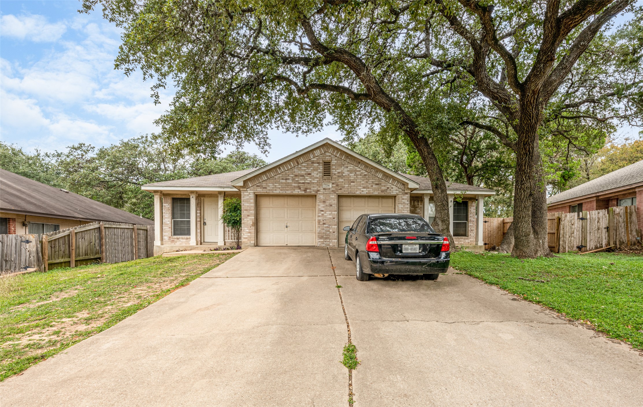 7216 Aldea Drive, Unit A Austin, TX 78745 - Photo 2 of 25 Two-unit brick-front property featuring two single-car garages and a concrete driveway