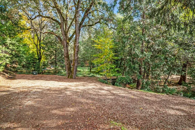 an aerial view of residential house with parking and trees