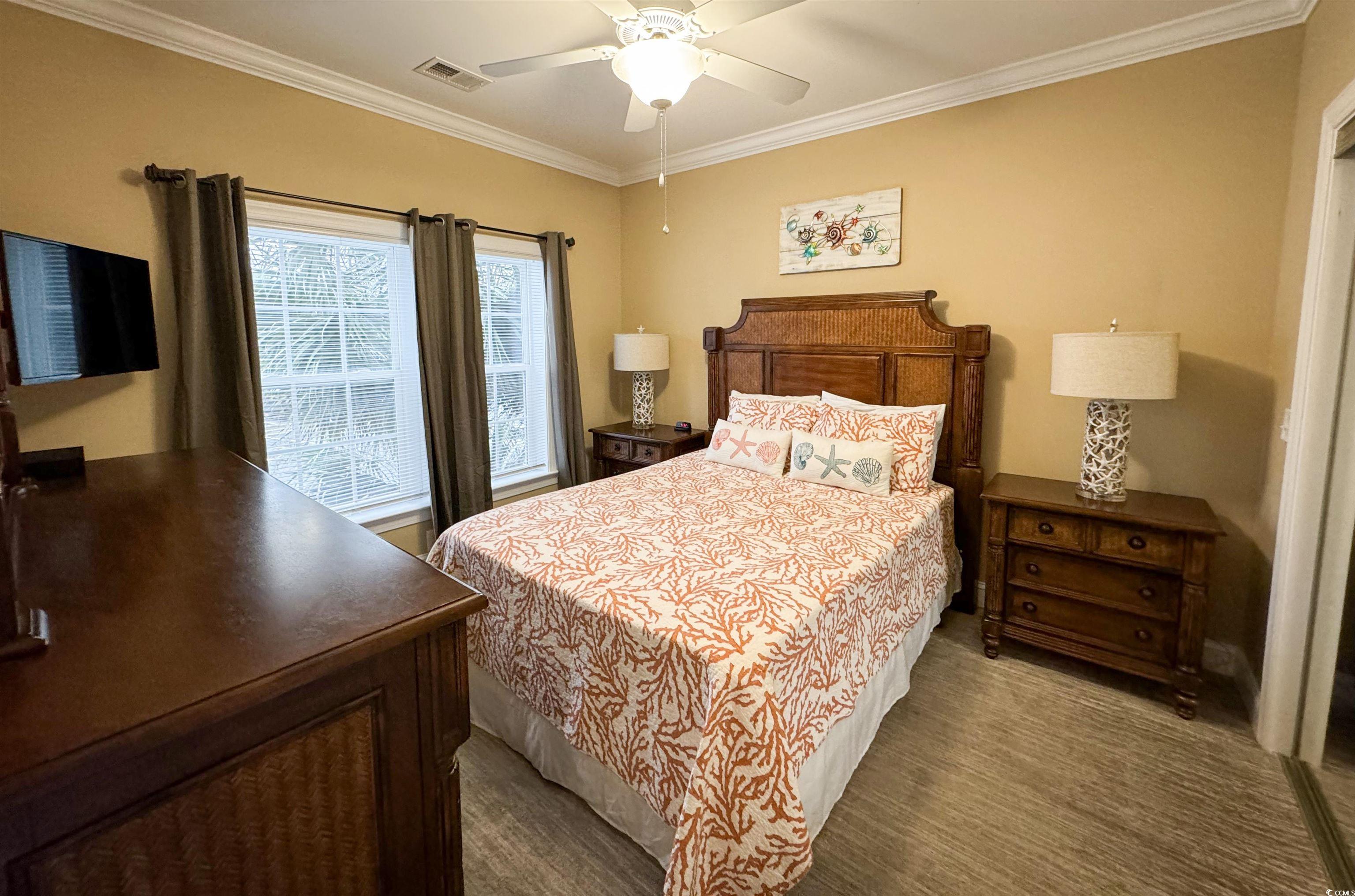 1004 Ray Costin Way, Unit 206 Murrells Inlet, SC 29576 - Photo 14 of 29 Guest bedroom featuring a ceiling fan, crown molding, and carpet