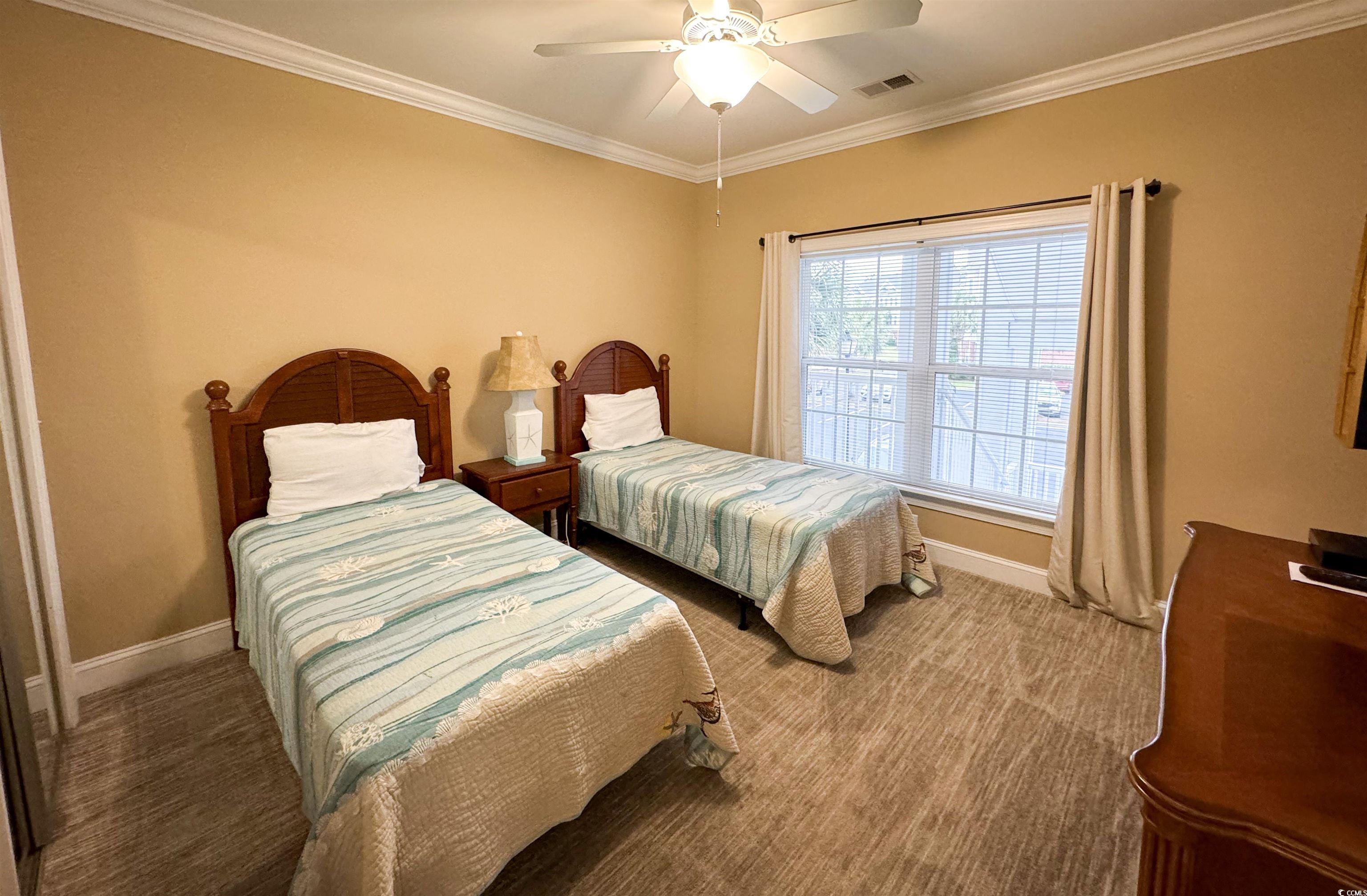 1004 Ray Costin Way, Unit 206 Murrells Inlet, SC 29576 - Photo 15 of 29 Guest bedroom featuring a ceiling fan, crown molding, and carpet