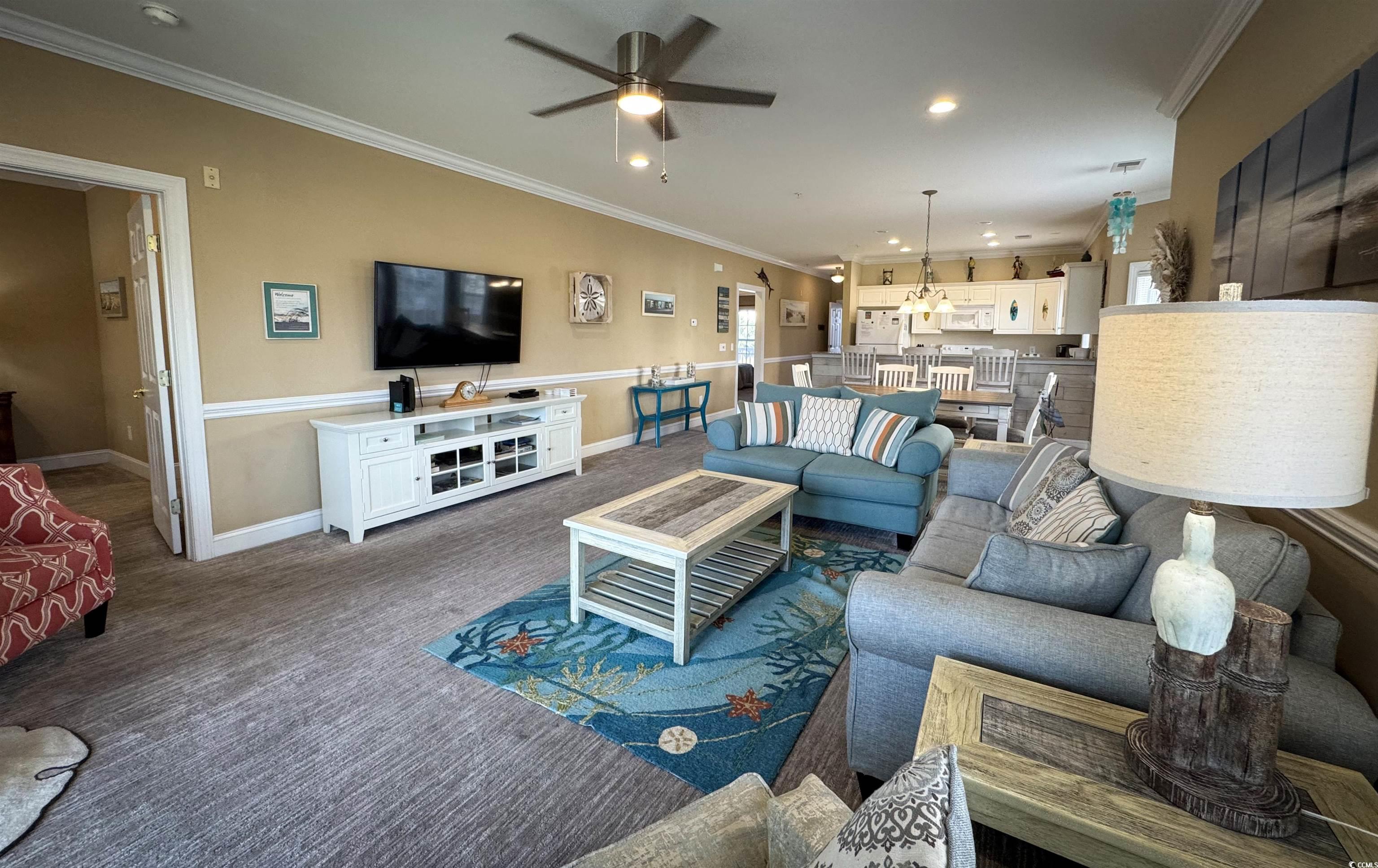 1004 Ray Costin Way, Unit 206 Murrells Inlet, SC 29576 - Photo 5 of 29 Living room featuring ceiling fan, crown molding, and dark colored carpet
