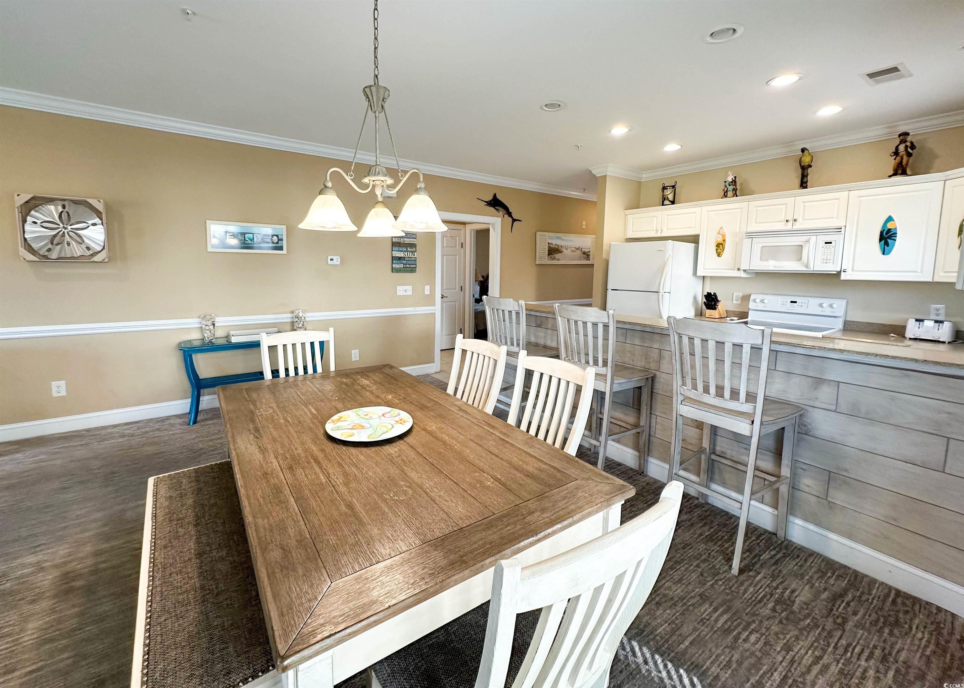 1004 Ray Costin Way, Unit 206 Murrells Inlet, SC 29576 - Photo 7 of 29 Dining space with dark hardwood / wood-style flooring and ornamental molding