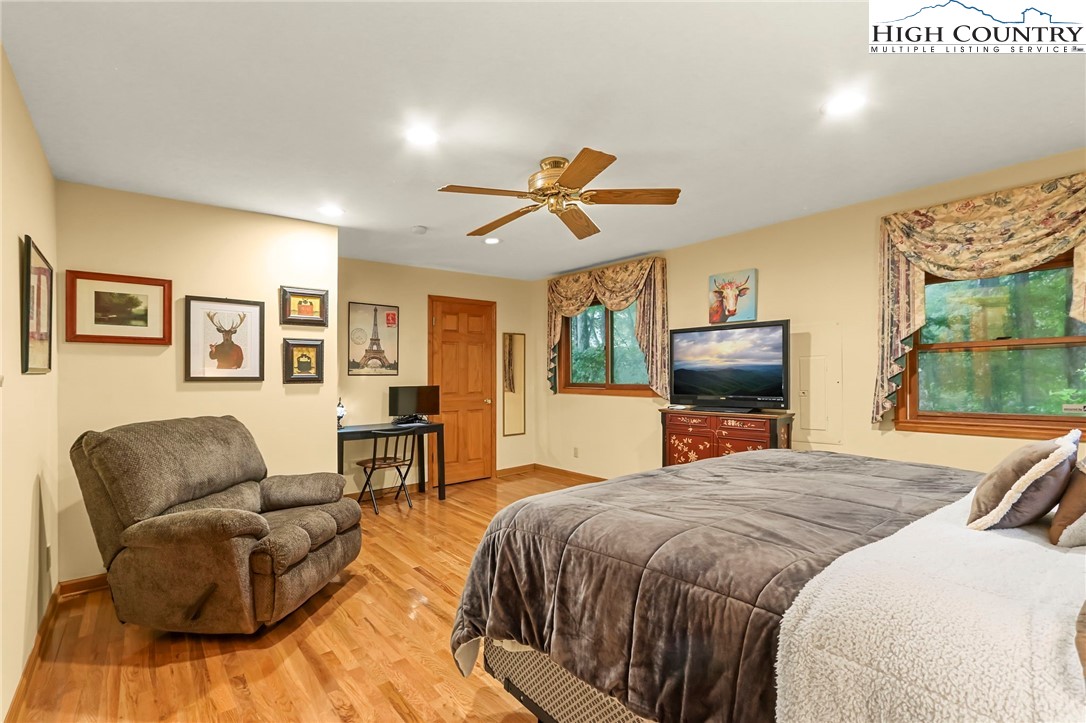 770 Grady Winkler Road Boone, NC 28607 - Photo 16 of 44 a spacious bedroom with a bed a couch and a flat screen tv