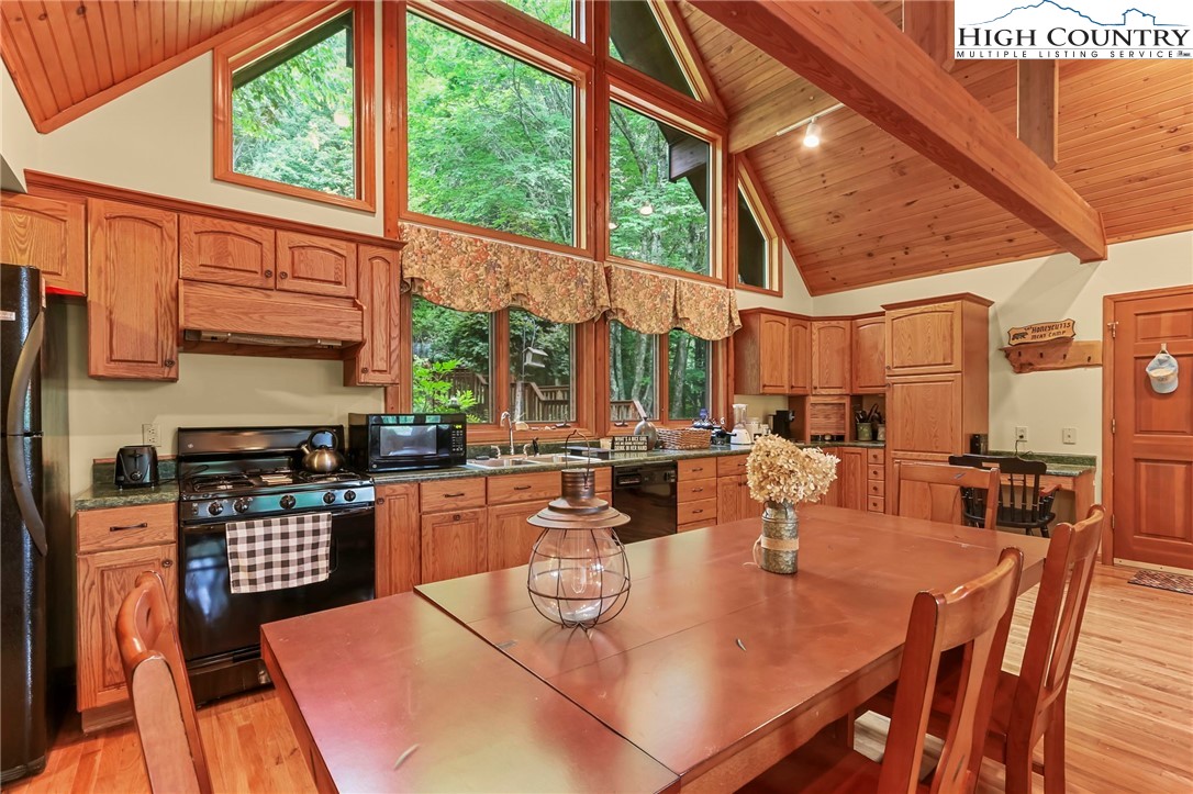 770 Grady Winkler Road Boone, NC 28607 - Photo 6 of 44 a kitchen with stainless steel appliances granite countertop a stove a table and chairs with wooden floor