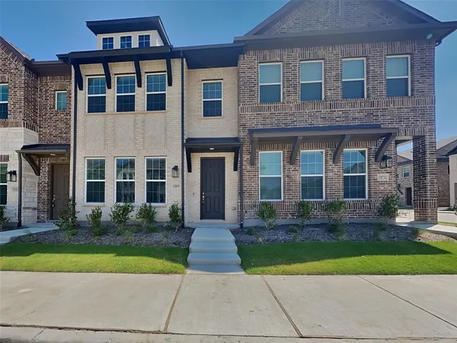 a front view of a brick house with a yard
