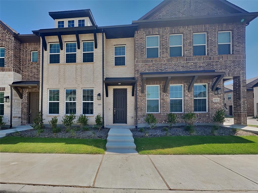 a front view of a brick house with a yard