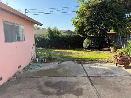 a view of a house with backyard and sitting area