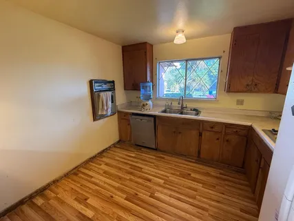 a kitchen with stainless steel appliances granite countertop a sink window and cabinets