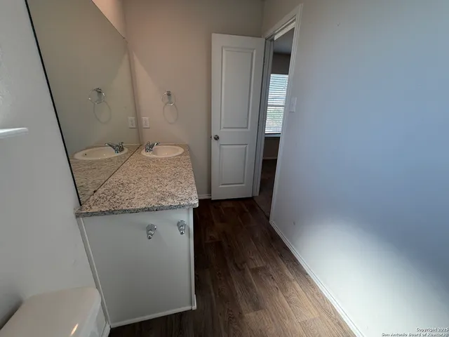 a bathroom with a granite countertop sink and a mirror