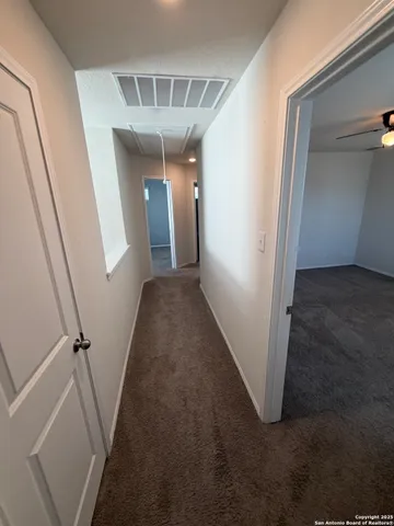 a view of a hallway with wooden floor and stairs
